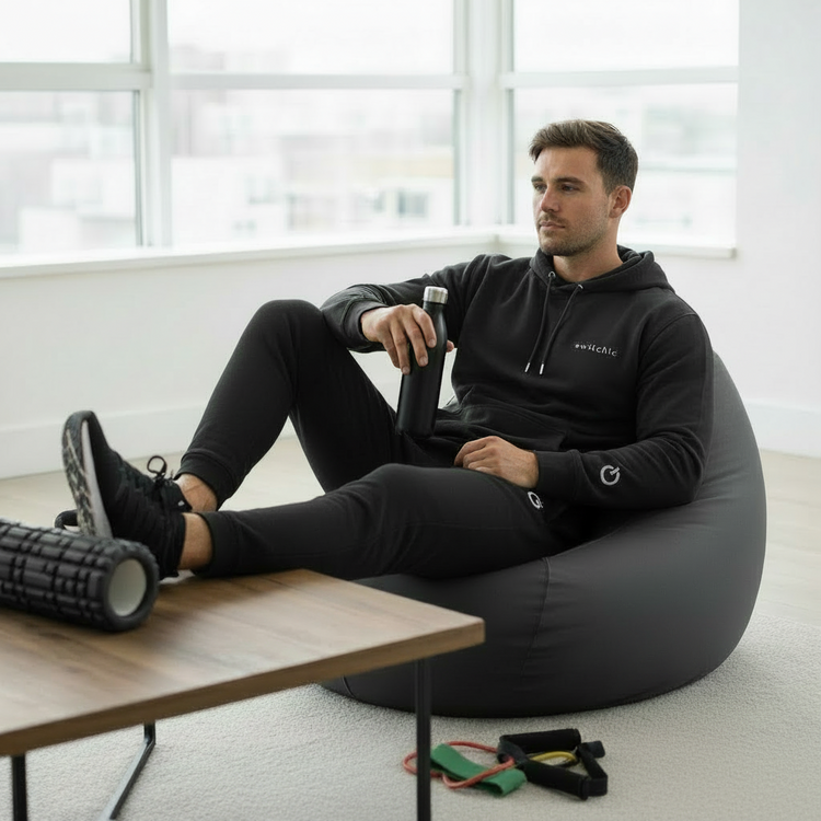 An athlete rests and recovers wearing a black Organic switch\off Premium Hoodie (White Embroidery) by An Athlete Trains | switch\off | An Athlete Trains