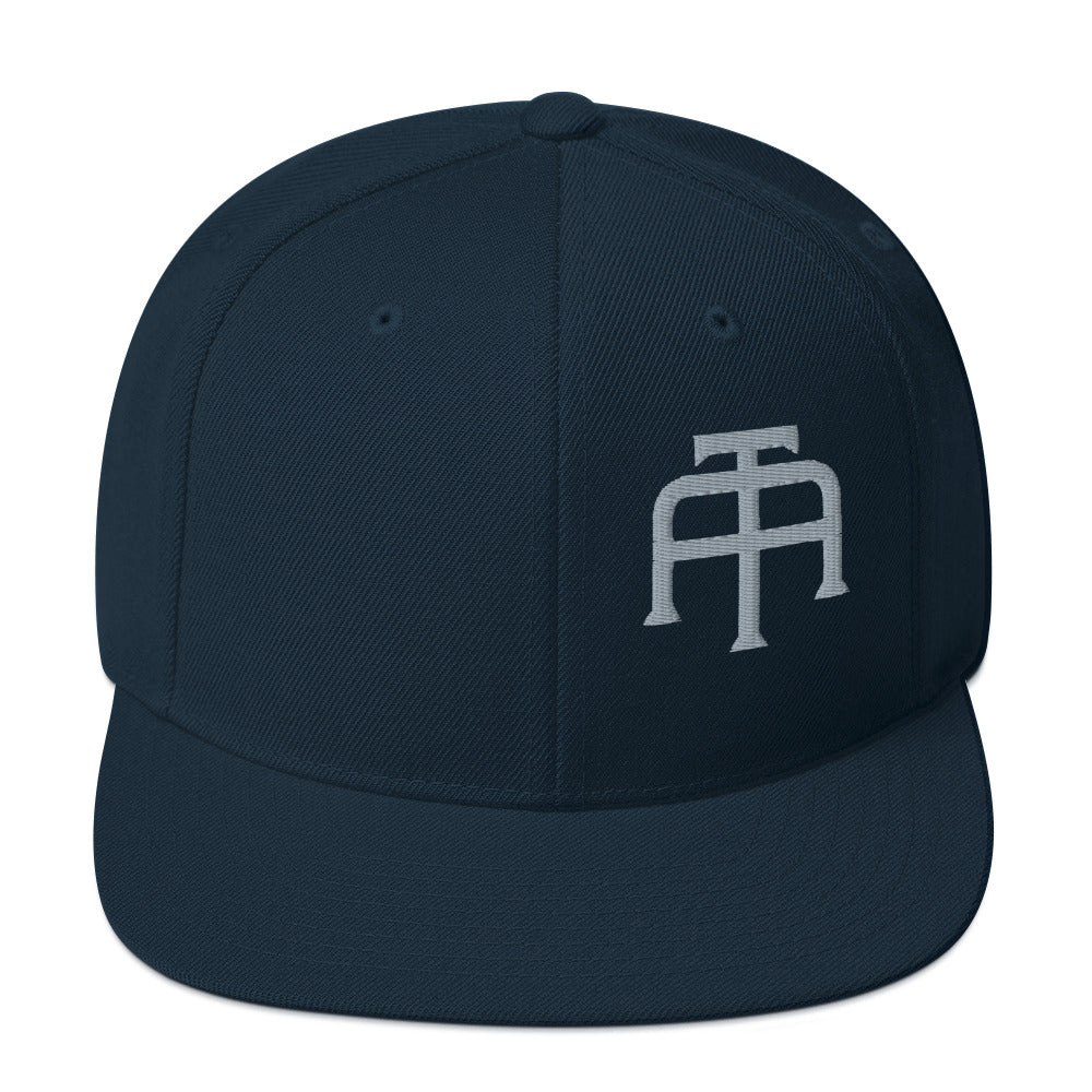 An Athlete Trains structured hat with a classic fit, flat brim, full buckram, and adjustable snap closure.