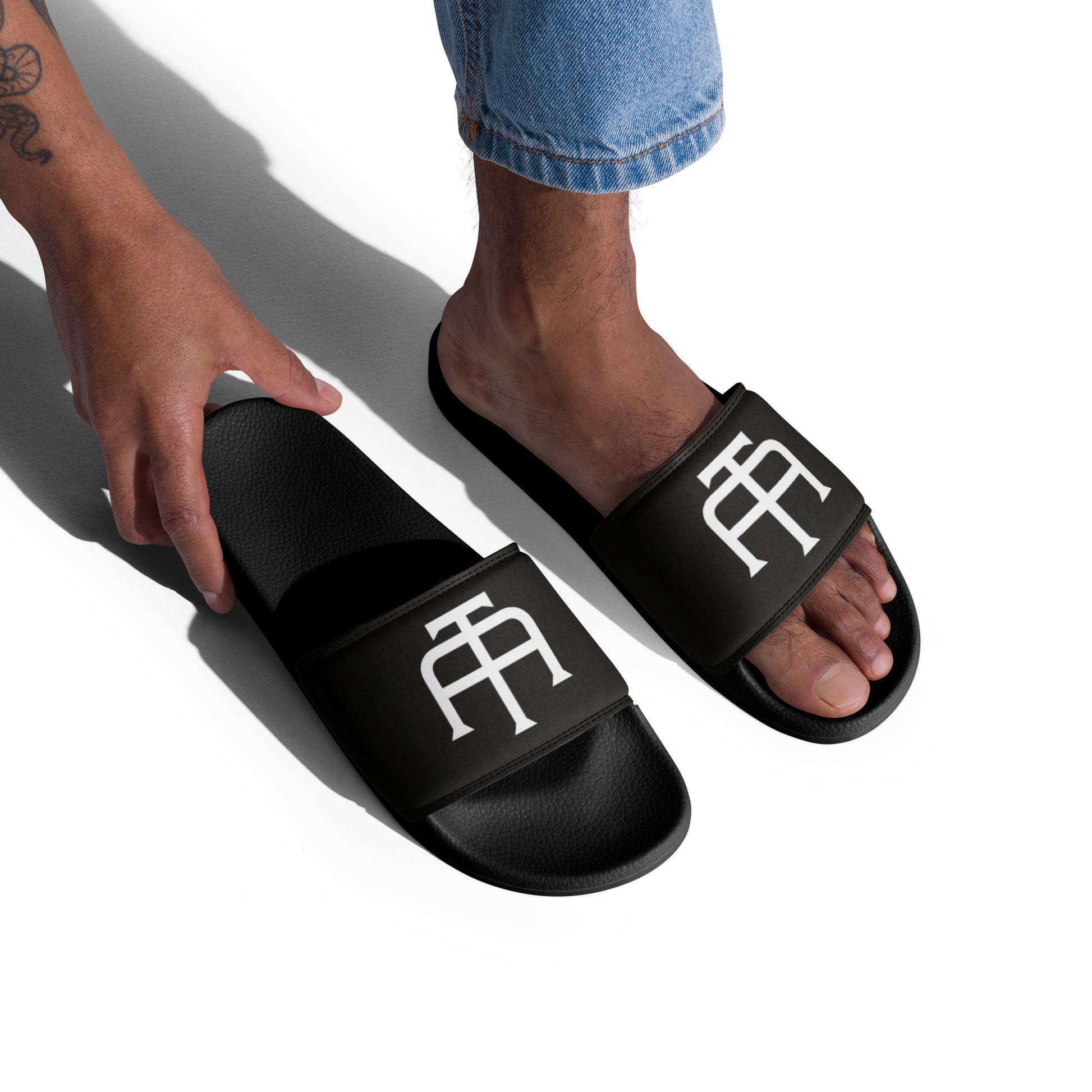 Men’s black slides with cushioned upper strap, textured footbed and a faux leather upper