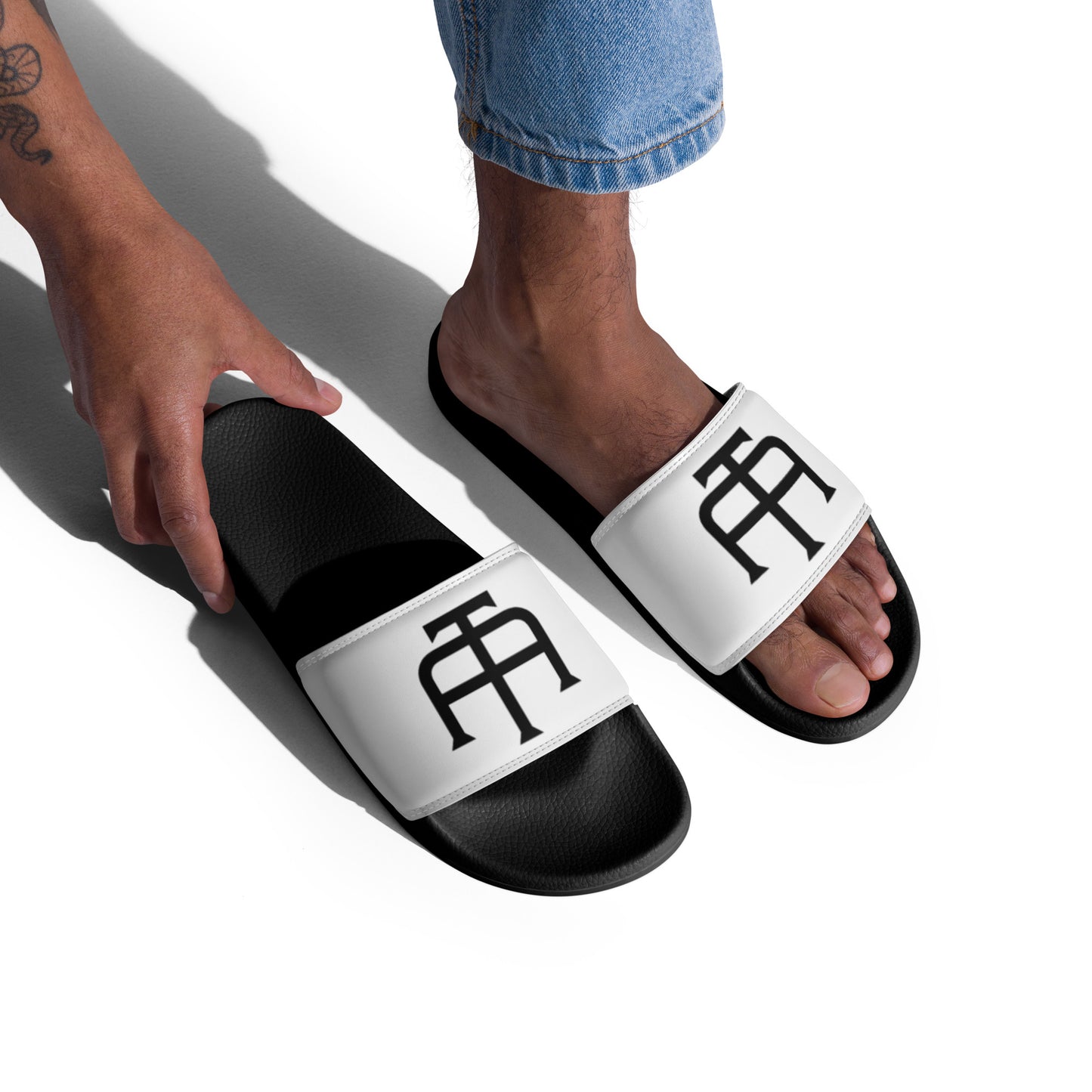 Men’s black slides with cushioned upper strap, textured footbed and a white faux leather upper