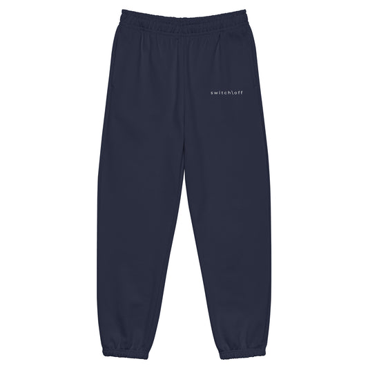 90s style boxy heavyweight sweatpants in navy color with white switch\off embroidery - An Athlete Trains. Front view 